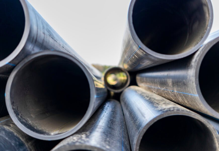 Water pipes for drinking water supply lie on the construction site. Preparation for earthworks for laying an underground pipeline. Modern water supply systems for a residential city